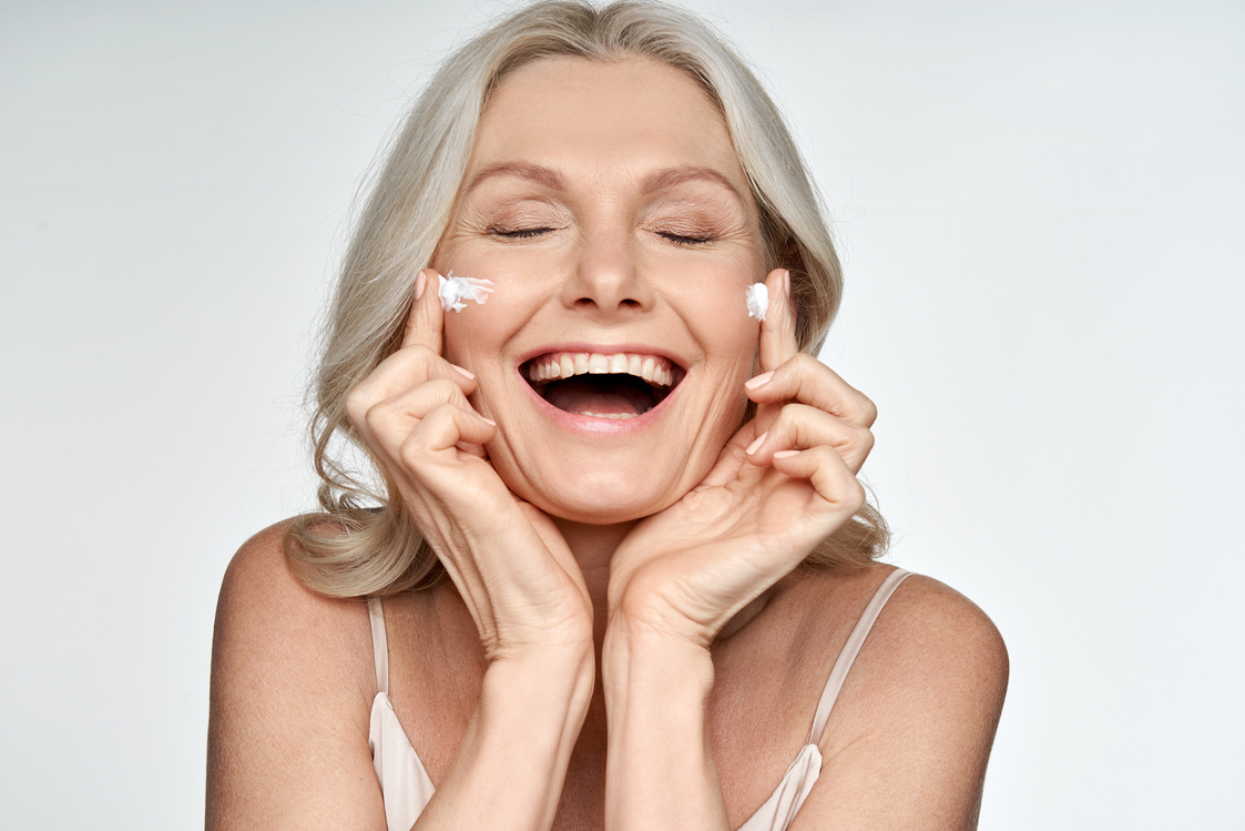 Woman Applying Cream on Face Isolated on White